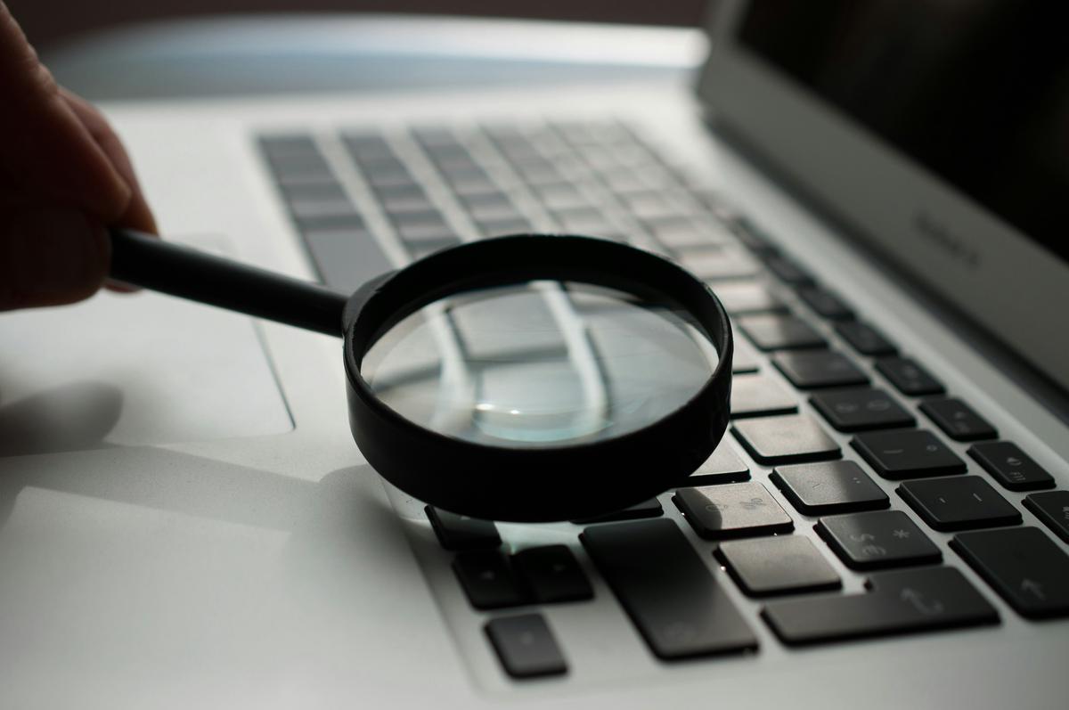 A magnifying glass hovering over a computer screen, representing search engine optimization